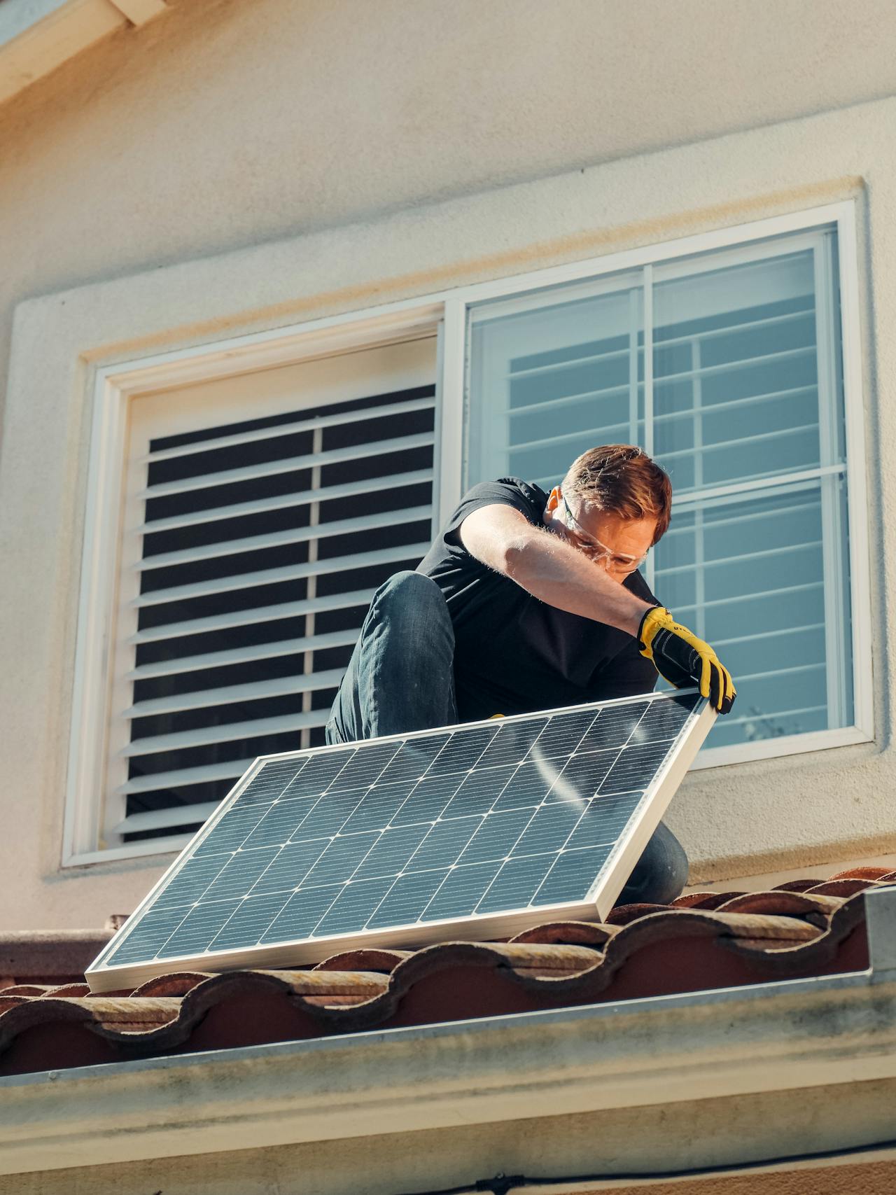 a man installing solar panel on the roof