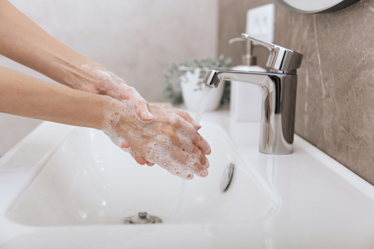 Washing hands under the flowing water tap